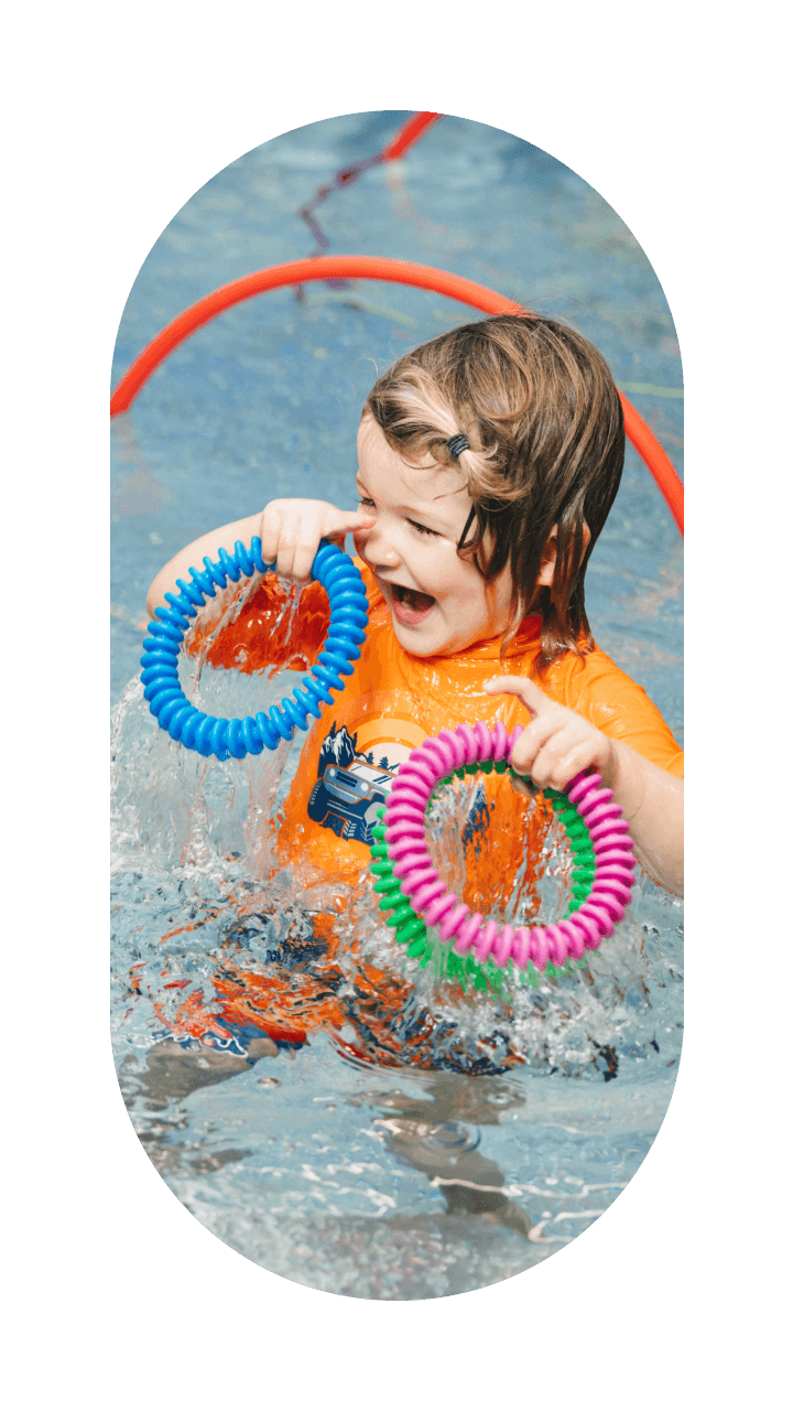 kid playing in pool with toys