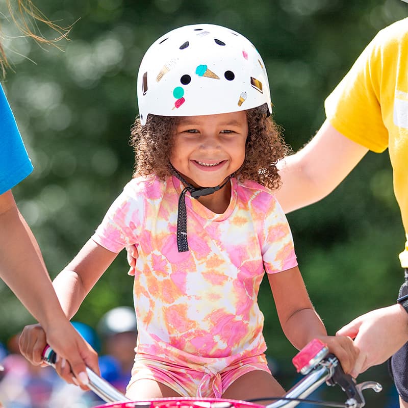 slider 3 girl learning to ride at bike camp in denver colorado